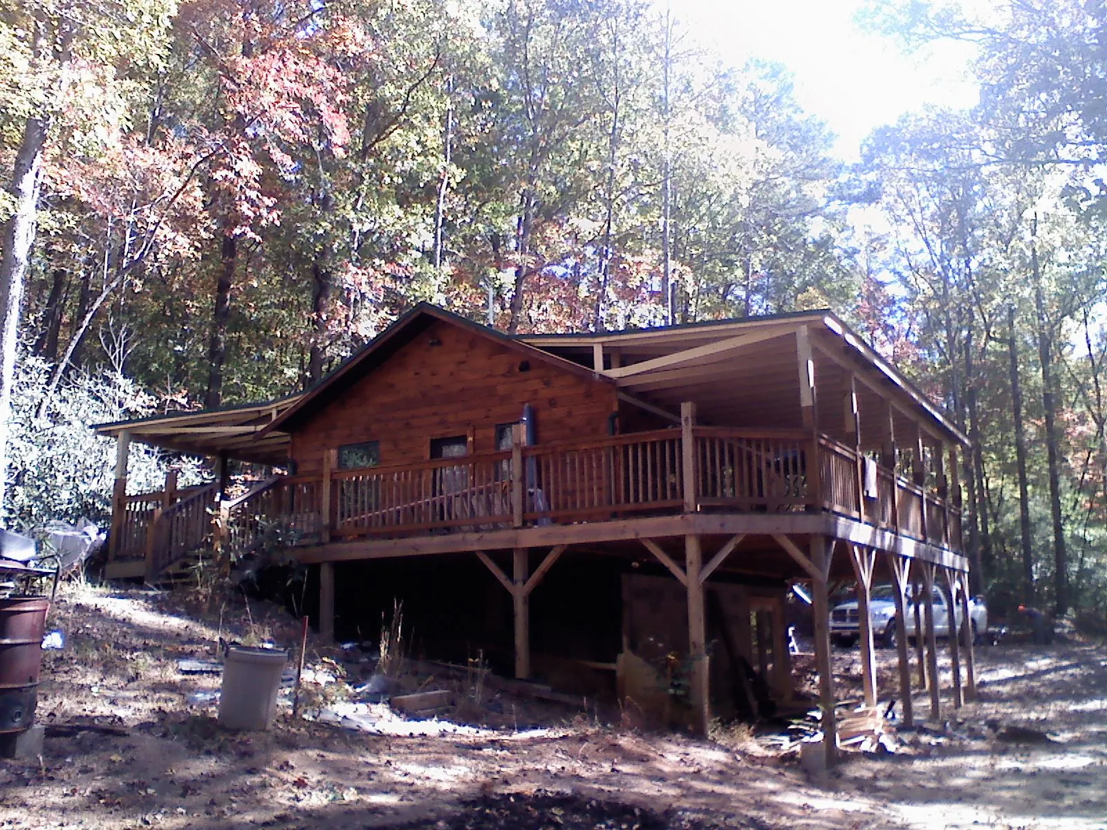 Log cabin with a wraparound porch and metal roof in the fall in Colonial Heights