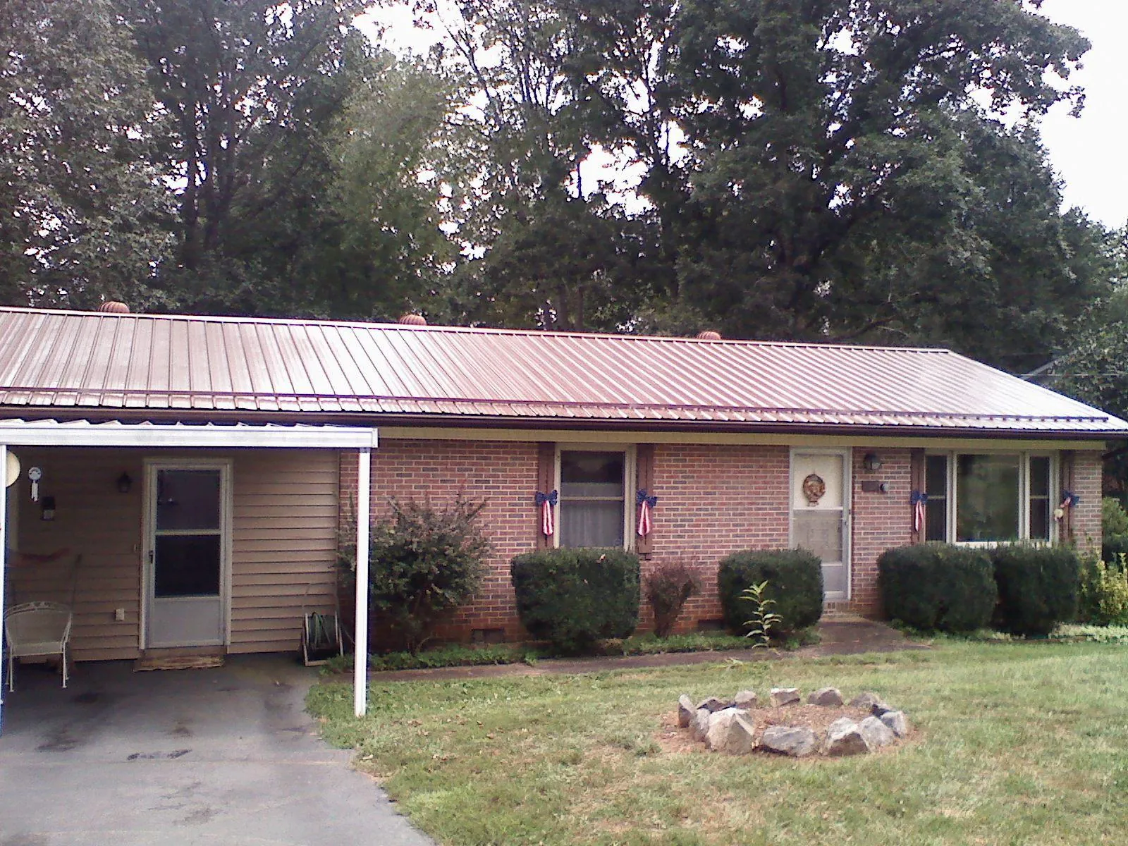 Bronze metal roof and carport on a brick ranch home — Roof Repair work by our crew in Colonial Heights