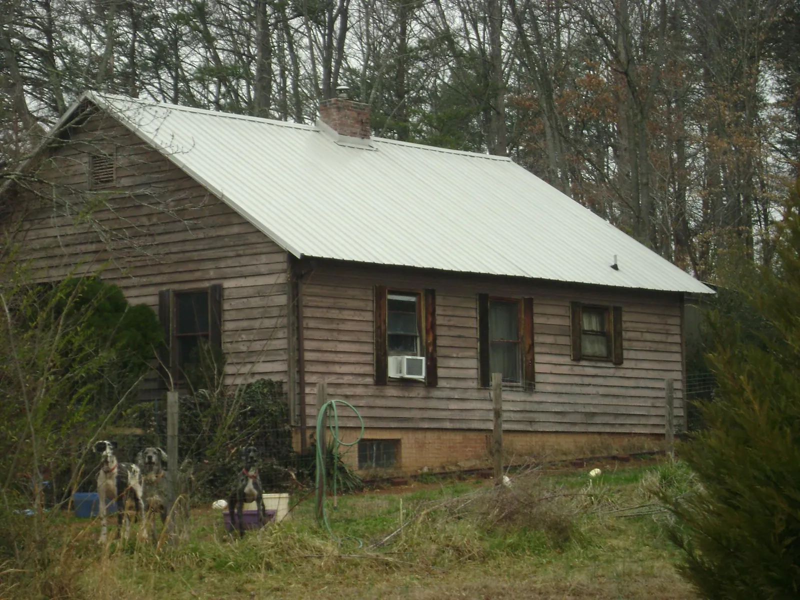 White metal roof on an old wood sided farmhouse, from a Metal Roof Installation job in Colonial Heights